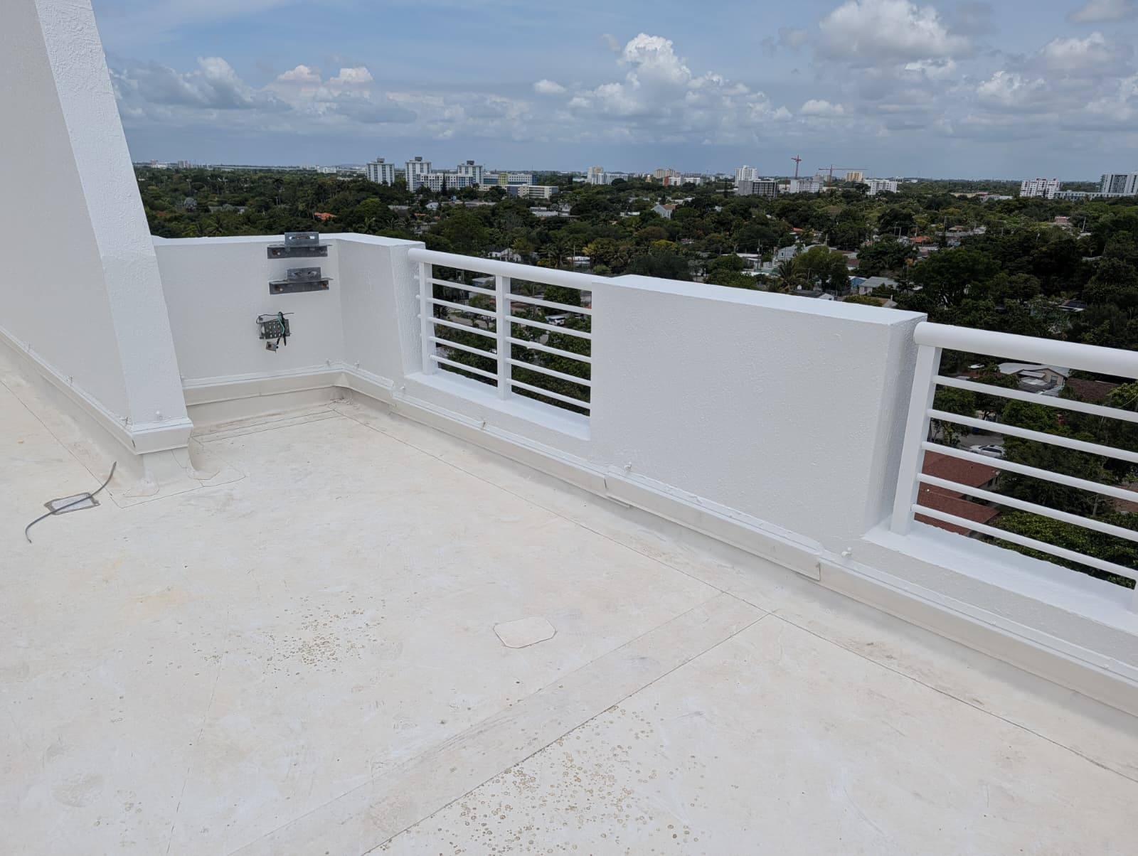 Authentic completed condo rooftop terrace concrete deck restoration with stucco parapet and railings