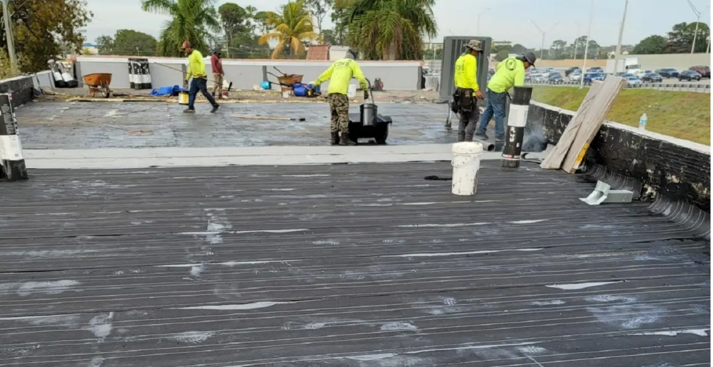 Authentic client crew applying heavy-duty waterproofing to structural concrete deck