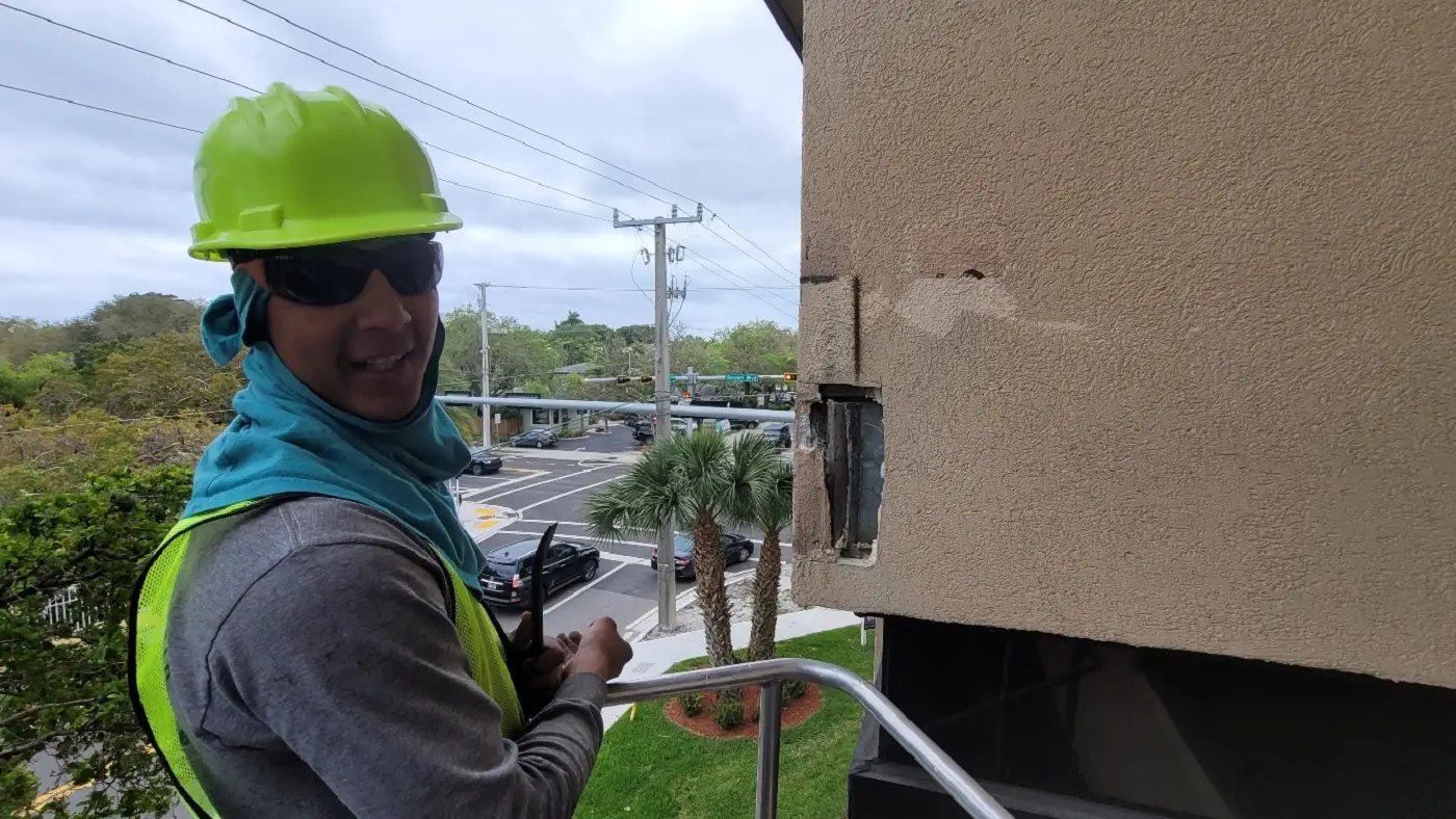 Authentic client high-reach stucco corner spall remediation on boom lift