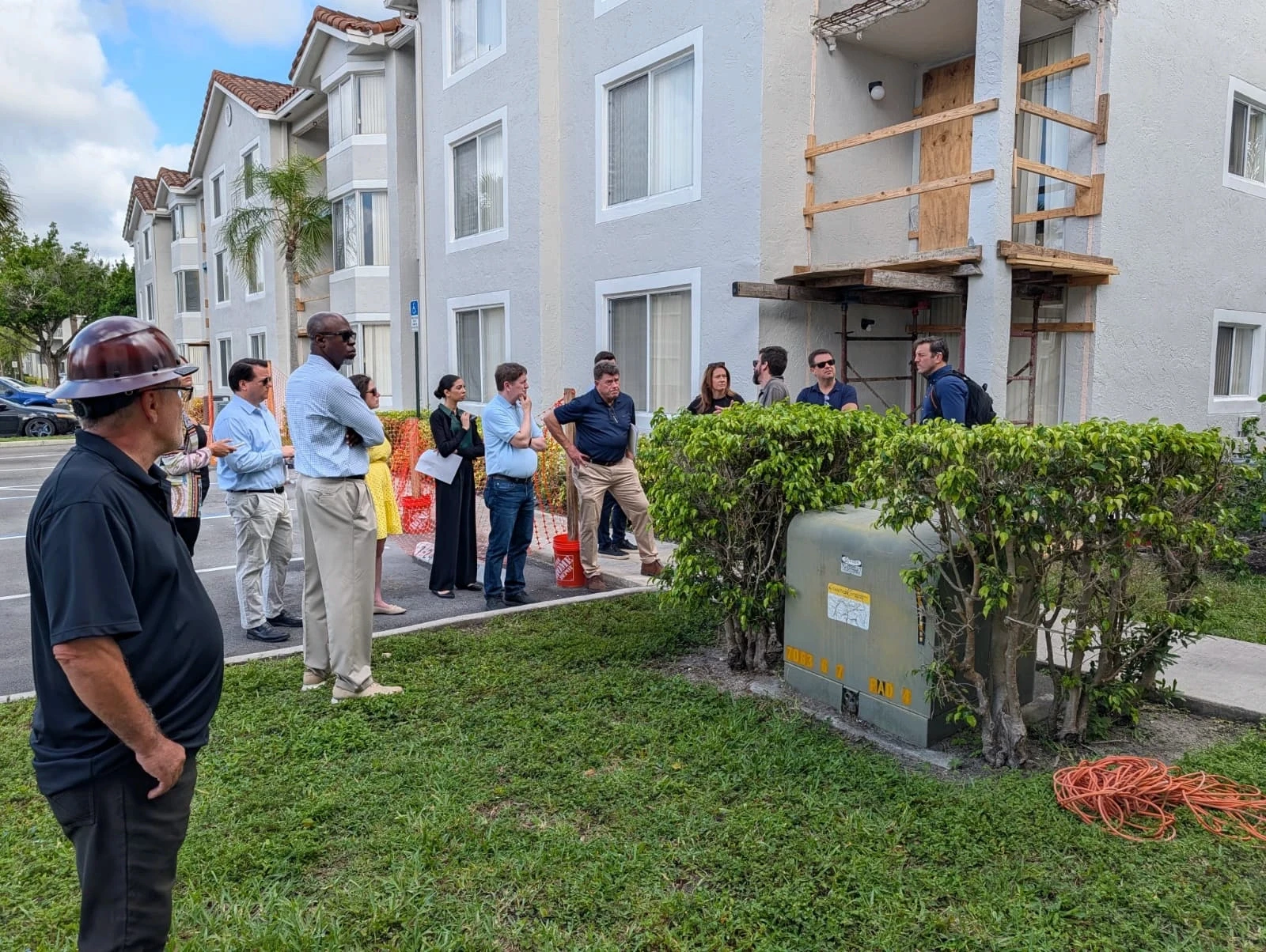 John Kraja inspecting multi-story condominium balcony concrete and railings during an HOA board structural review