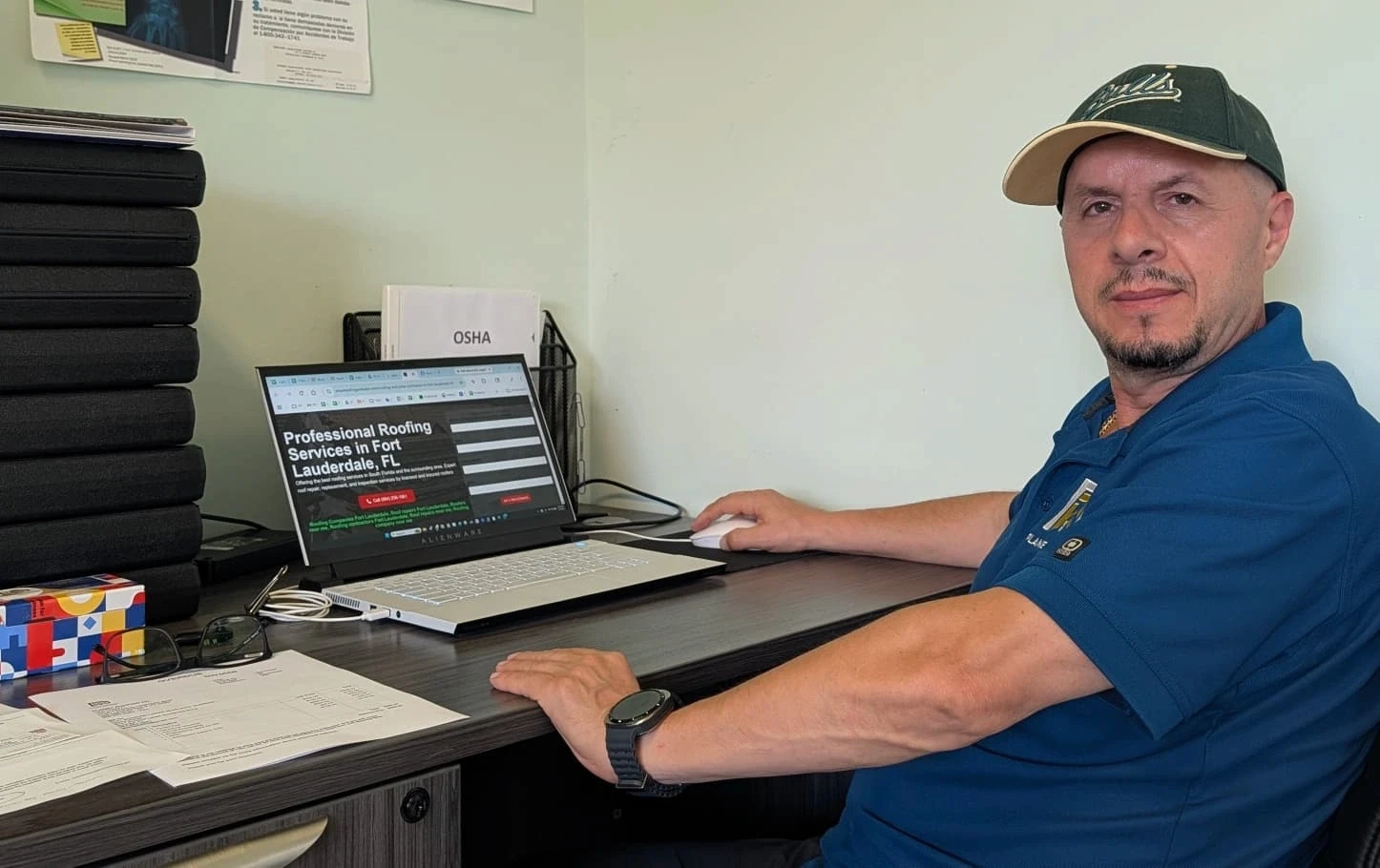 Planet Construction qualifying contractor John Kraja reviewing architectural drawings and itemized estimates at estimating desk