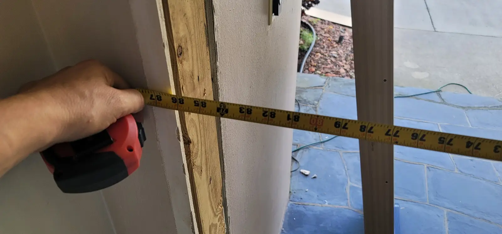Authentic client measuring structural masonry buck opening and interior CBS wall